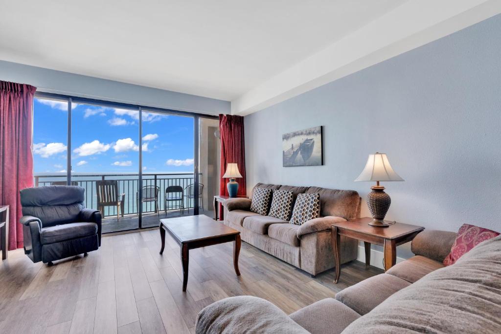 uma sala de estar com um sofá e cadeiras e uma grande janela em Scenic Views from the balcony at Ocean Forest Plaza Condos em Myrtle Beach