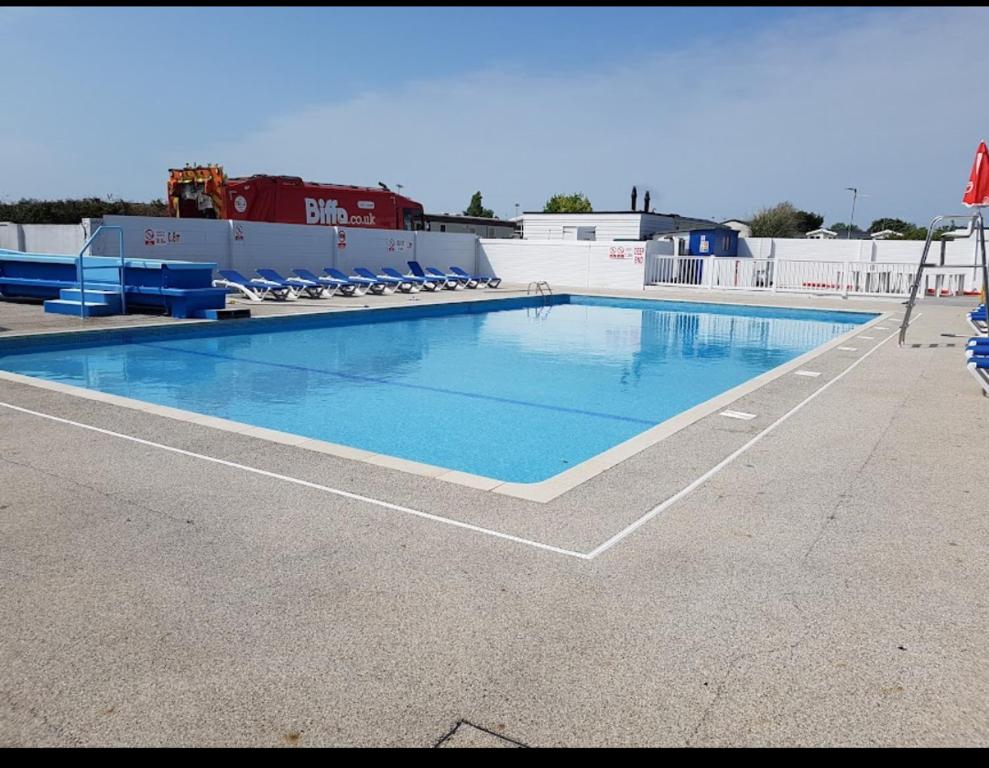 - une grande piscine avec des chaises bleues dans un bâtiment dans l'établissement Carnival Our lovely home from home, à Great Yarmouth