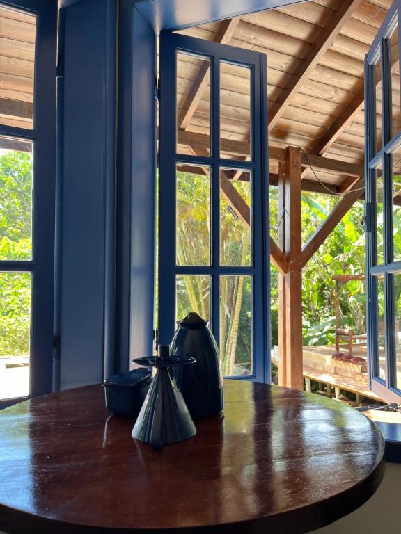 a wooden table in a room with windows at Pousada Maikai Garden in Porto Belo