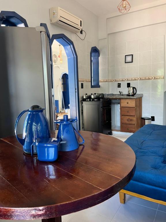 a kitchen with a wooden table with blue vases on it at Pousada Maikai Garden in Porto Belo