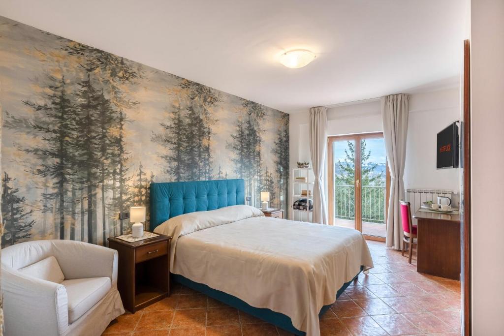 a bedroom with a bed and a wall with trees at Hotel Rasinus in Roccaraso