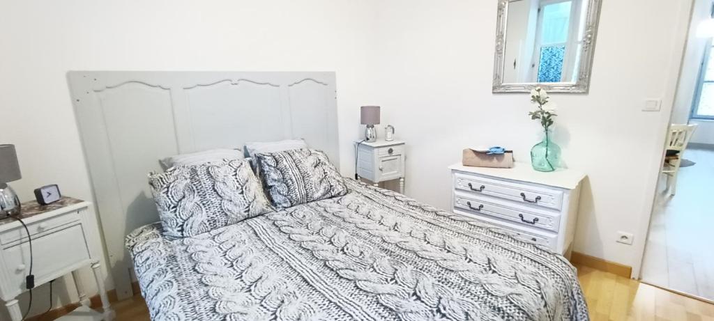 a bedroom with a white bed and a dresser at Appartement cosy à 2 pas des rues piétonnes in Chalon-sur-Saône