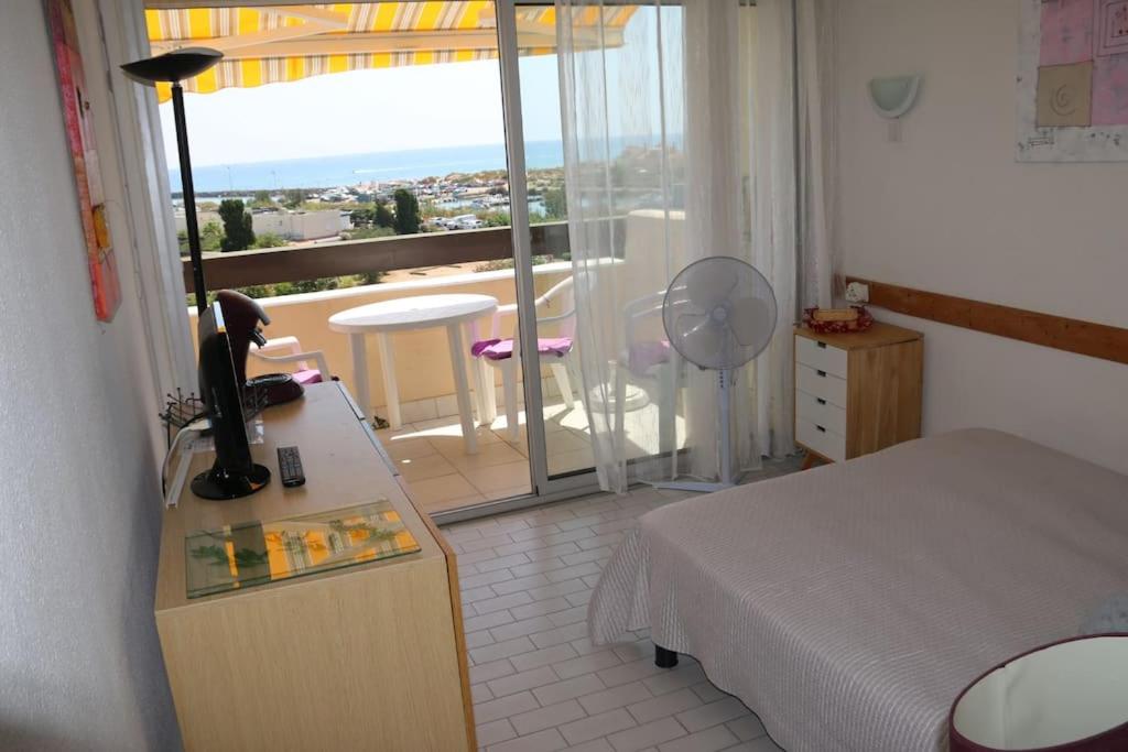 une chambre avec un lit et un balcon avec vue dans l'établissement Studio 653, Port Nature 6 au village naturiste, au Cap d'Agde