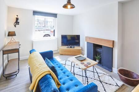 a living room with a blue couch and a tv at Host & Stay - 2 College Square in Stokesley
