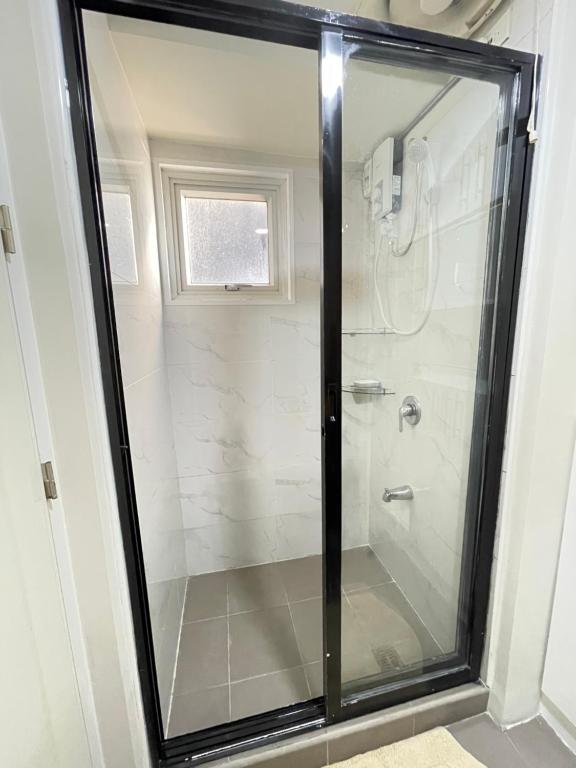 a shower with a glass door in a bathroom at Centrio Tower condominium in Cagayan de Oro