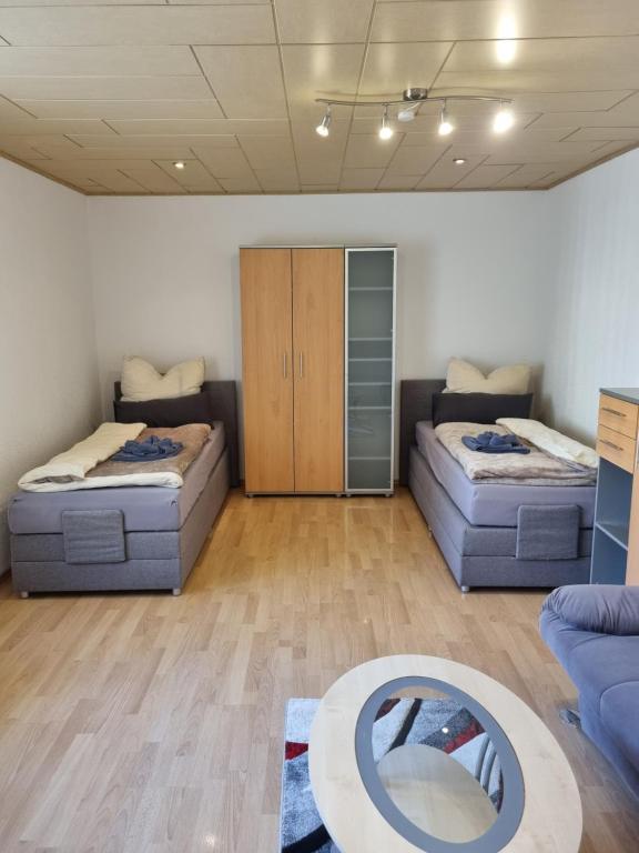 ein Wohnzimmer mit 2 Betten und einem Tisch in der Unterkunft MontApart Geiseltal in Braunsbedra