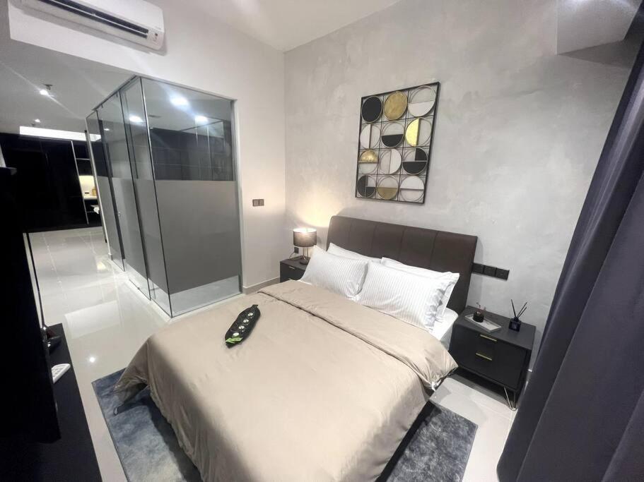 een slaapkamer met een groot bed en een glazen douche bij Novo KL, Astonishing Unique Executive Suite in Kuala Lumpur