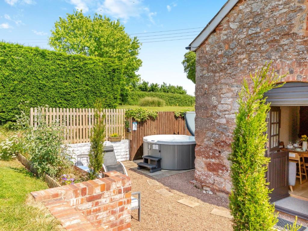 a garden with a table and a brick building at 3 bed property in Exeter 82586 in Clyst Saint Mary