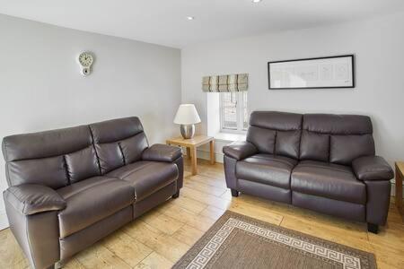 a living room with a leather couch and a table at Host & Stay - Mill in Consett