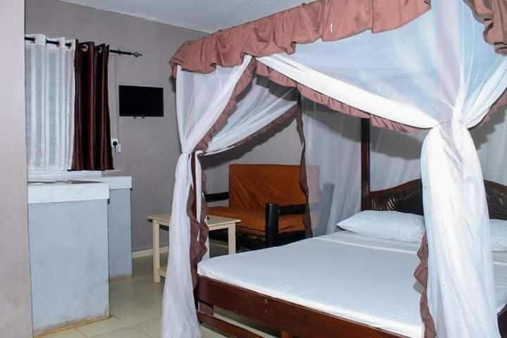 1 dormitorio con 1 cama con dosel en Mtwapa Empire holiday Apartments, en Mtwapa