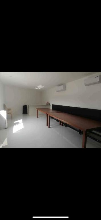 una habitación con dos mesas y un banco en ella en Cavite’s Cozy Villa en Imus