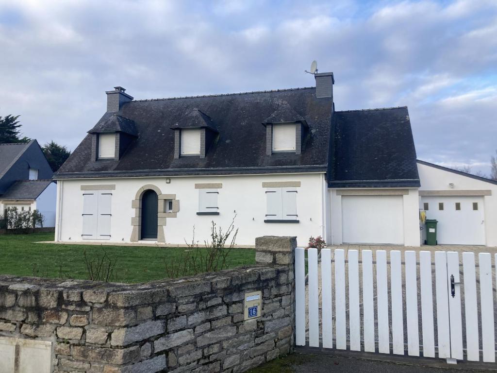 a white house with a white fence at LE COQ - Maison 10 personnes - Locmariaquer in Locmariaquer