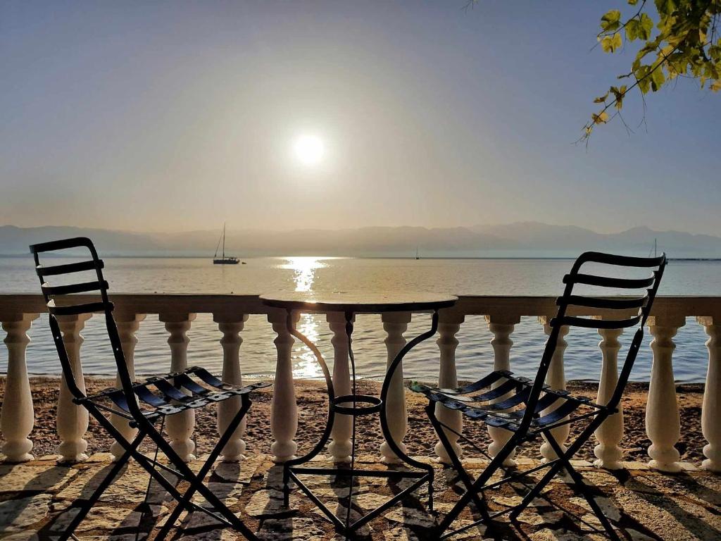 2 Stühle und ein Tisch am Strand in der Unterkunft Tropical Beach A1 in Kalamaki