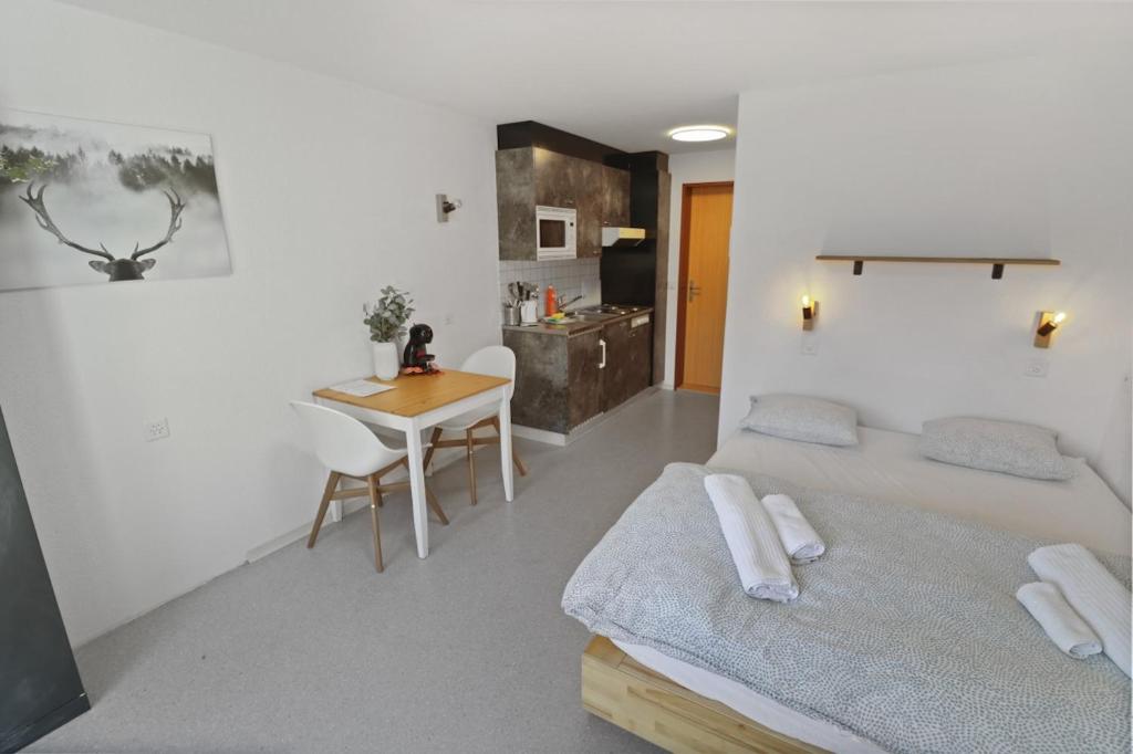a bedroom with a bed and a table and a desk at Studio charmant avec vue imprenable in Saas-Fee
