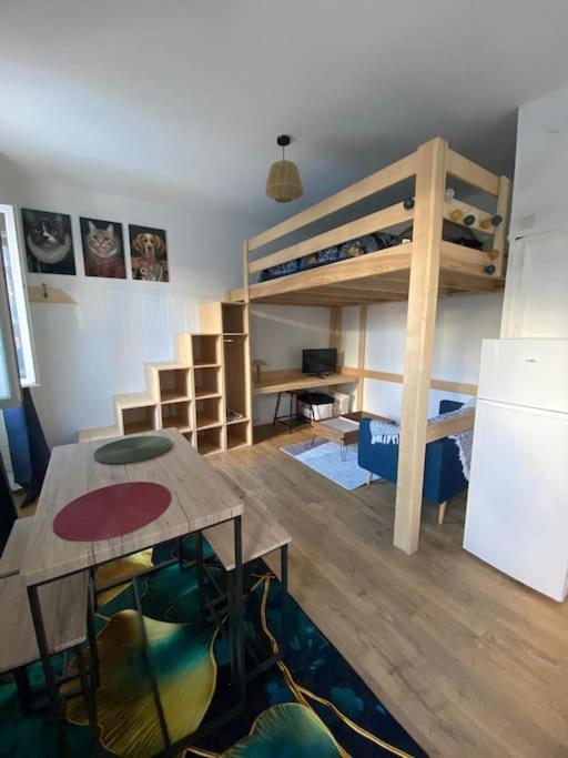 a room with a bunk bed and a table and a desk at Studio paisible à Lorient ! in Lorient