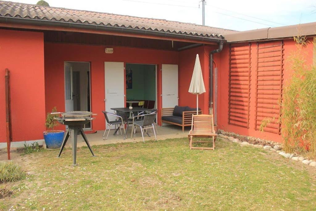 a patio of a house with a table and chairs at appartement confort 5 personnes in Grandson