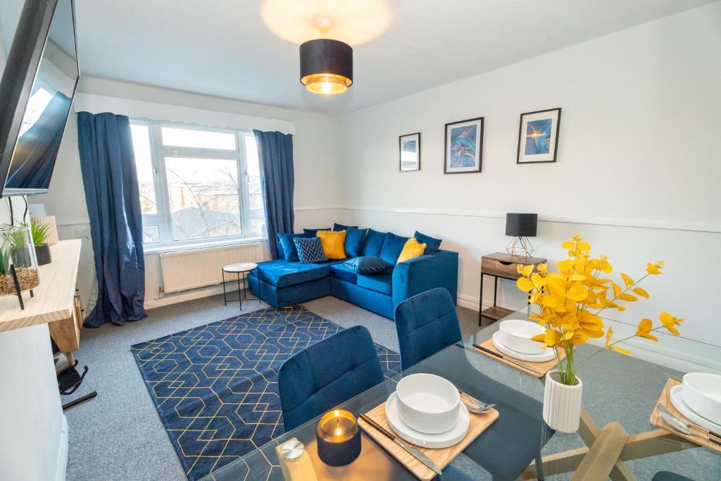 a living room with a blue couch and a table at Cosy Flat 10 mins to Central London sleeps 5 in London