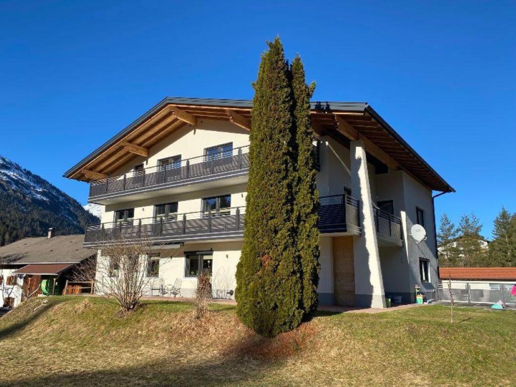 a large house with a tree in front of it at Natura Aparts in Stanzach