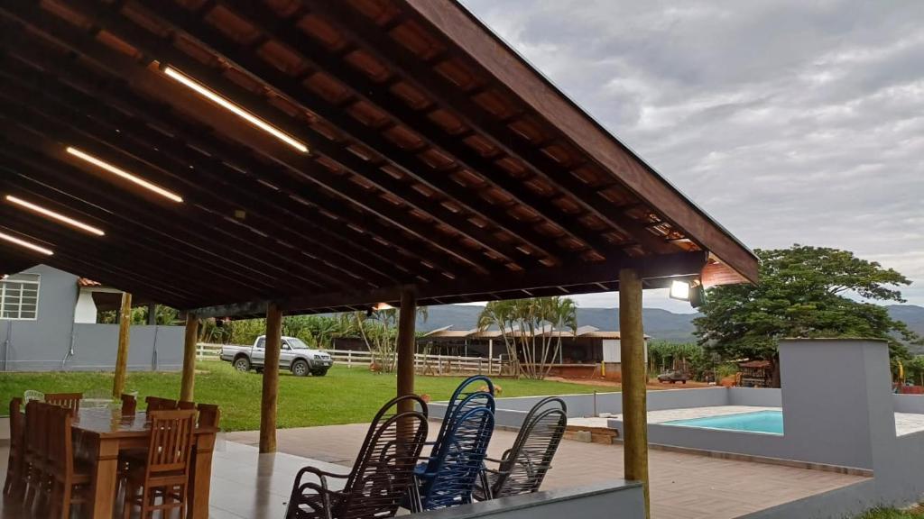 een patio met stoelen, een tafel en een zwembad bij Sítio Vitória in Delfinópolis