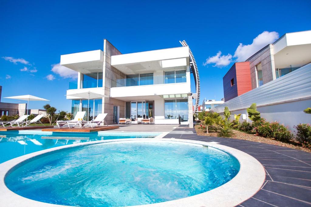 a house with a swimming pool in front of it at Vivo Mare Beachfront-Seaview Villas in Ayia Napa