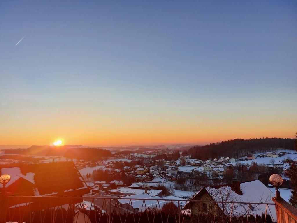 een zonsondergang boven een stad met sneeuw op de grond bij Ferienwohnung zur Schildkröte in Fürstenstein