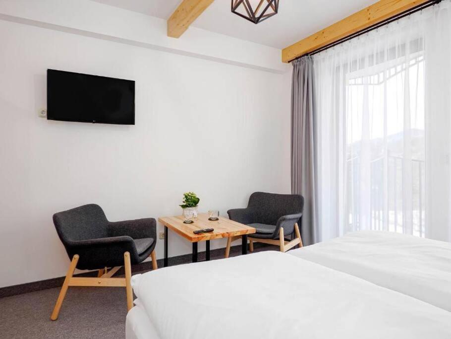 a hotel room with a bed and two chairs and a table at Studio Apartment with Mountain View in Zakopane