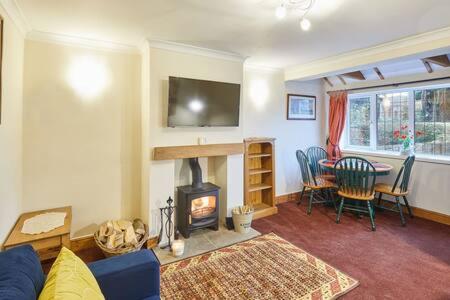 a living room with a fireplace and a dining table at Host & Stay - Jackson Cottage in Thirsk
