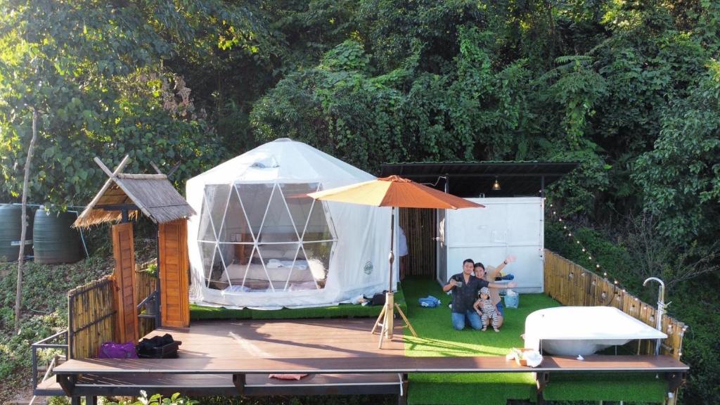 um grupo de pessoas sentadas numa tenda em Tham Ma Chard ทำมะชาด em Ban Ko Doi Tung