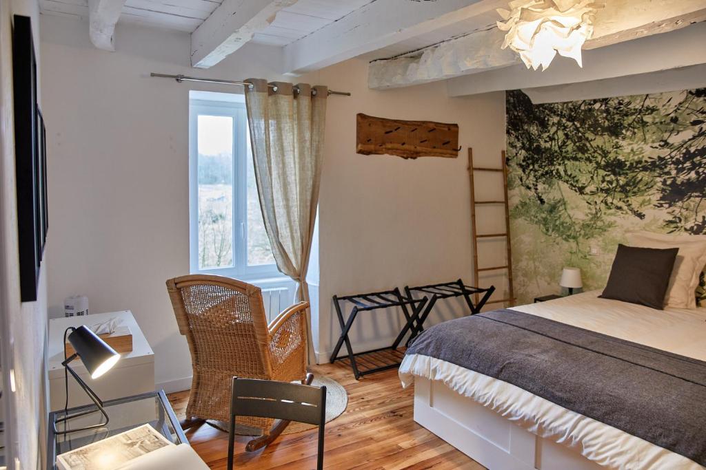 een slaapkamer met een bed en een groot raam bij La Breizhidence in Combourg
