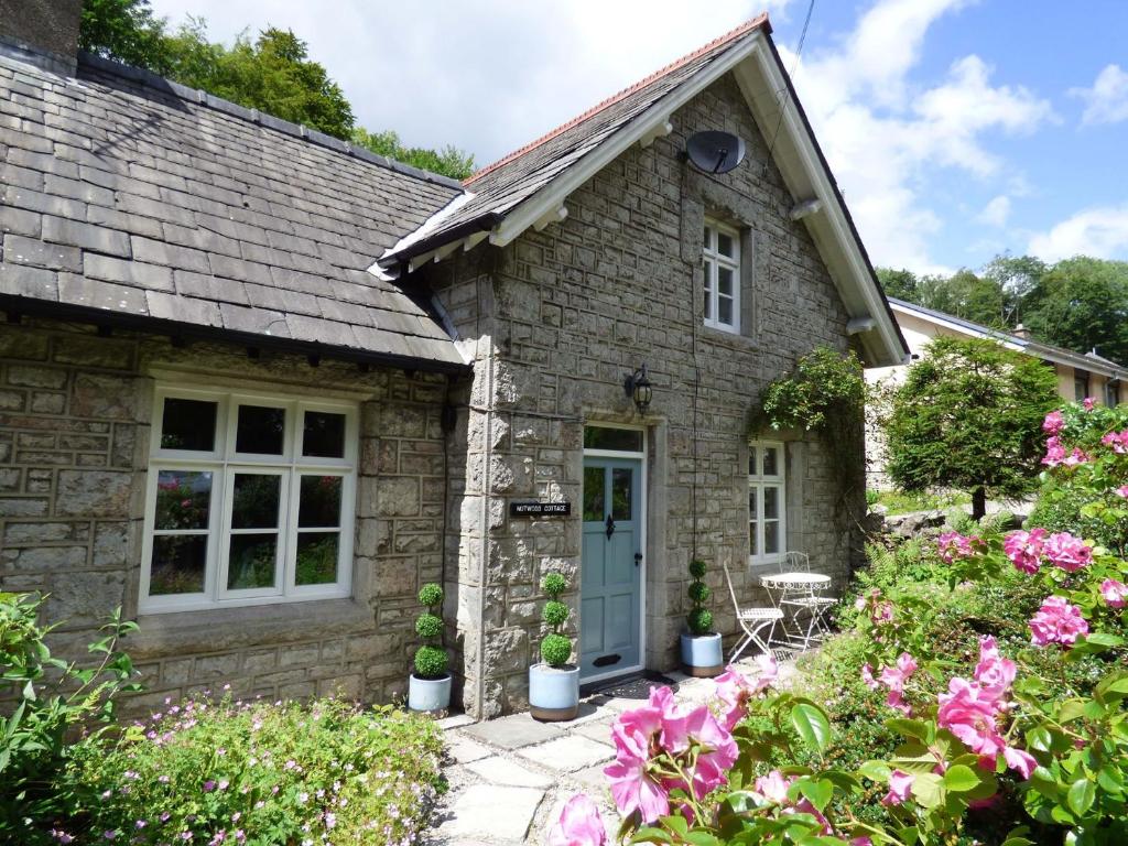 a stone cottage with a blue door and flowers at 2 Bed in Grange Over Sands 78871 in Grange Over Sands