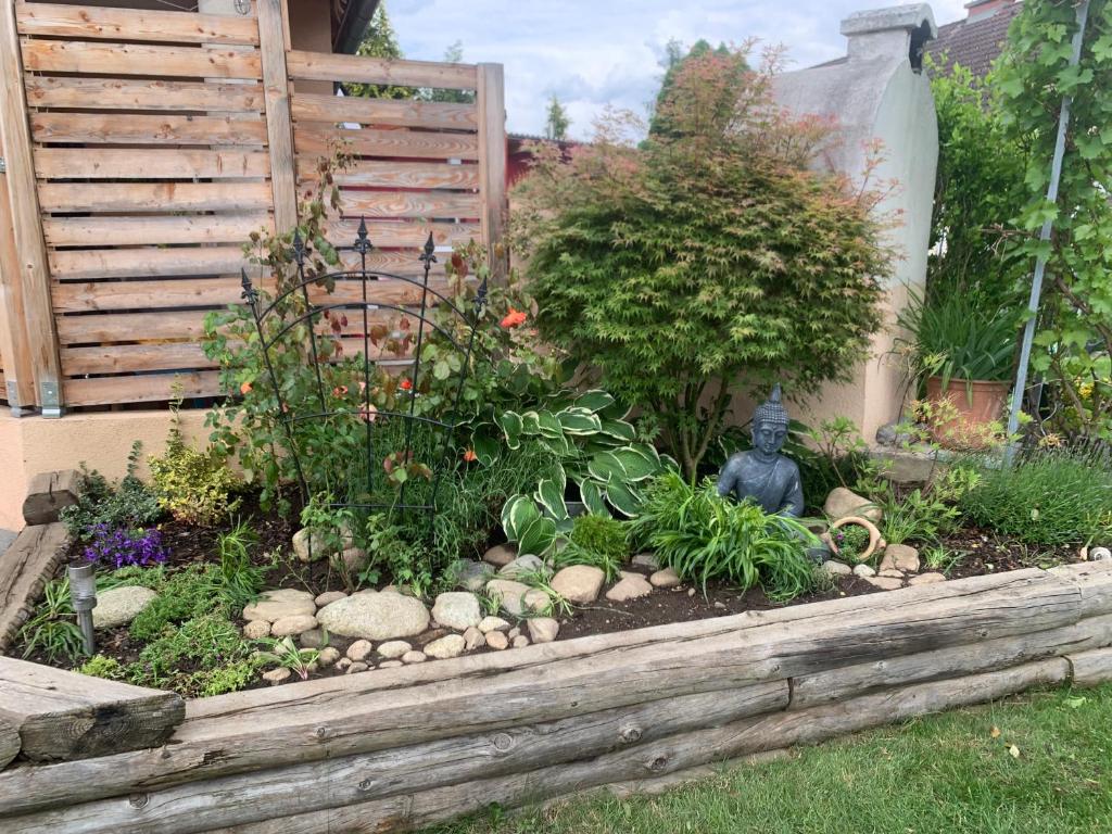 un jardín con plantas y una estatua en un patio en Schmuckes Einfamilienwohnhaus, en Spielberg