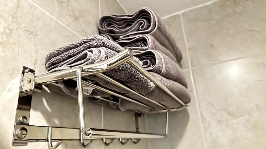a metal towel rack with two towels on it at Fast WiFi • Wash/Dry • SoftBed • Parking • 24/7 Security in Guadalajara