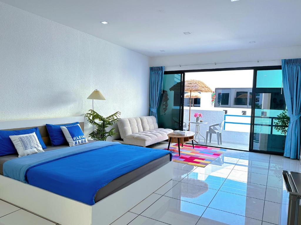 Un dormitorio con una cama azul y un balcón. en Mona Lisa pool villa, en Pattaya South