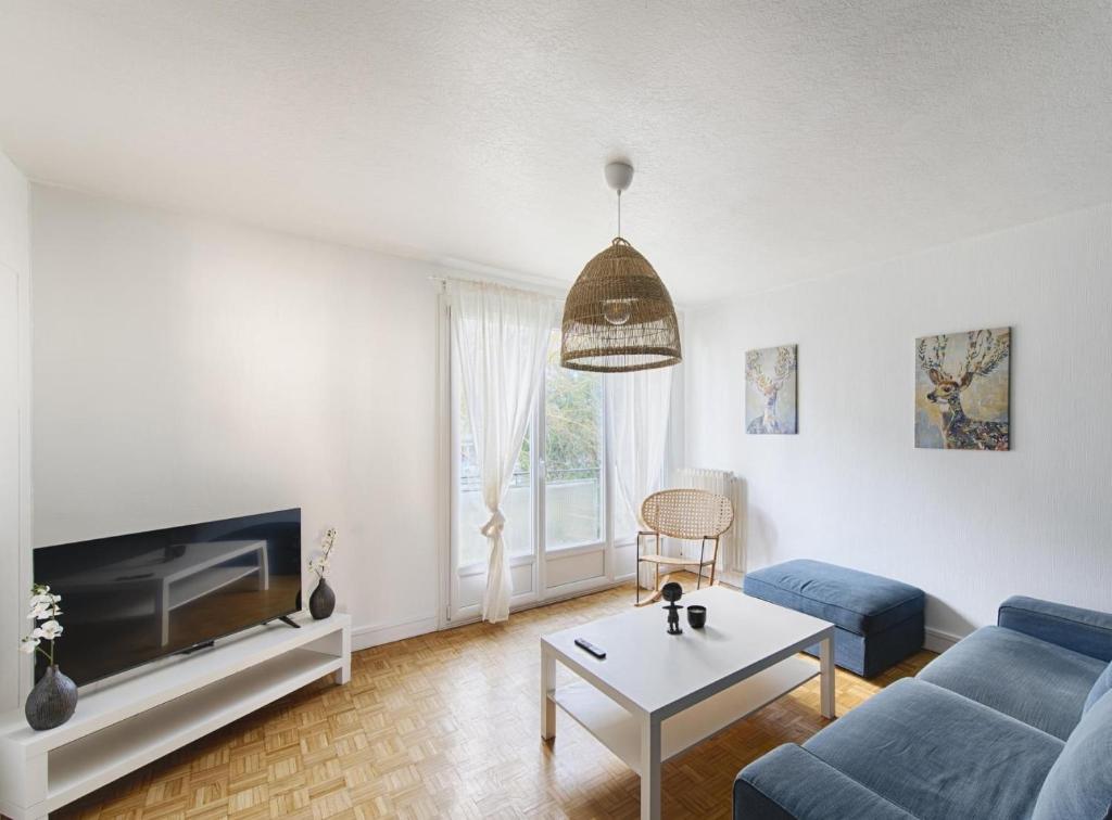 un salon avec un canapé bleu et une table dans l'établissement Appartement 3 chambres, à Rennes