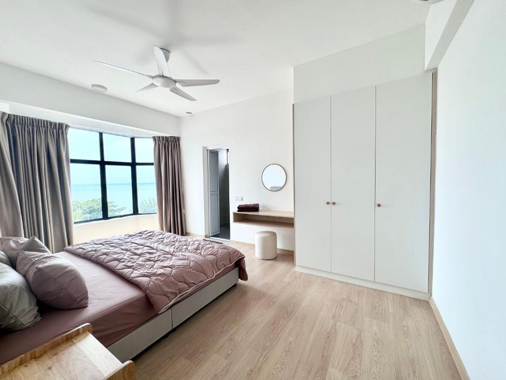 um quarto com uma cama e uma grande janela em Seaview 2 bedroom apartment Mutiara Beach Resort by ISRA em Tangga Batu