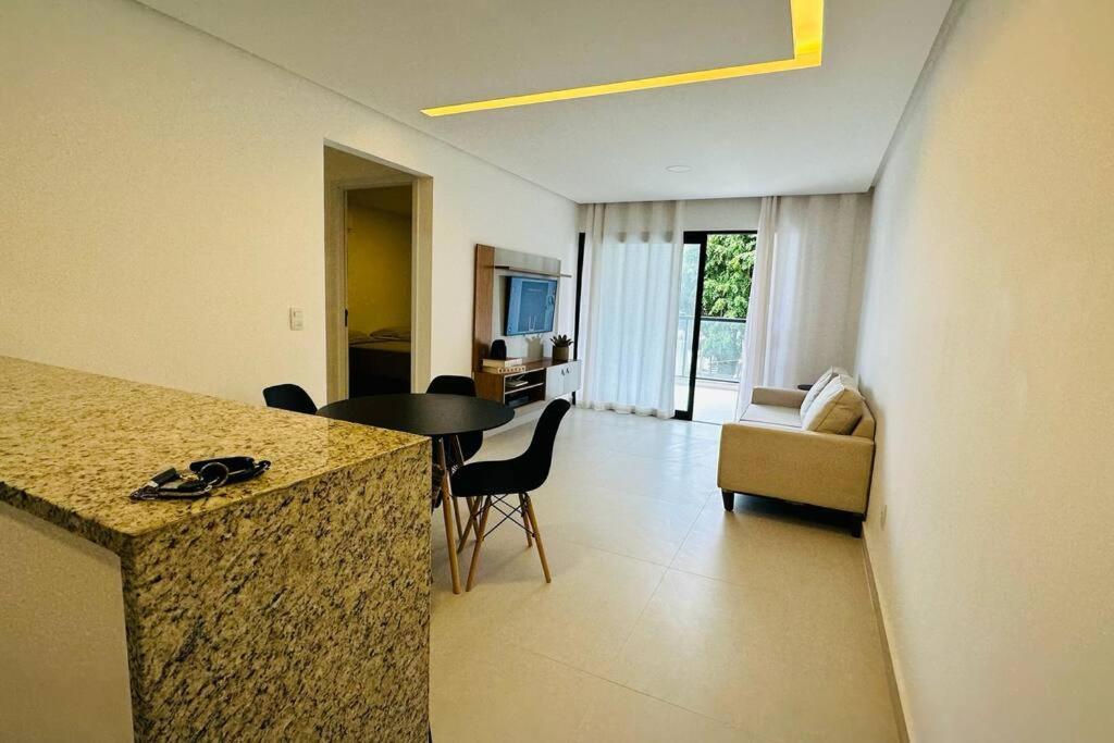 een keuken en een woonkamer met een tafel en een bank bij BlueCoast 205 Apartment in Rio das Ostras