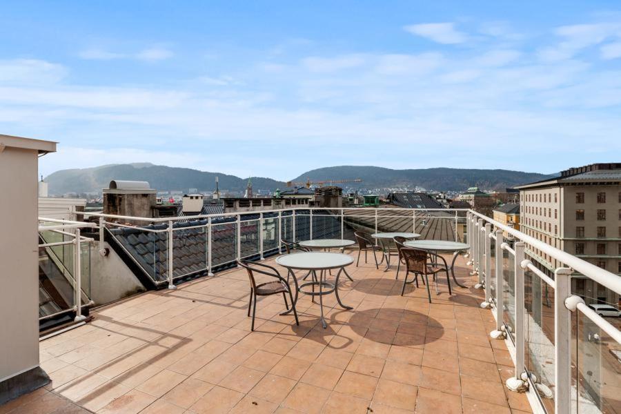 a patio with tables and chairs on a balcony at Apartment Bergen Central in Bergen