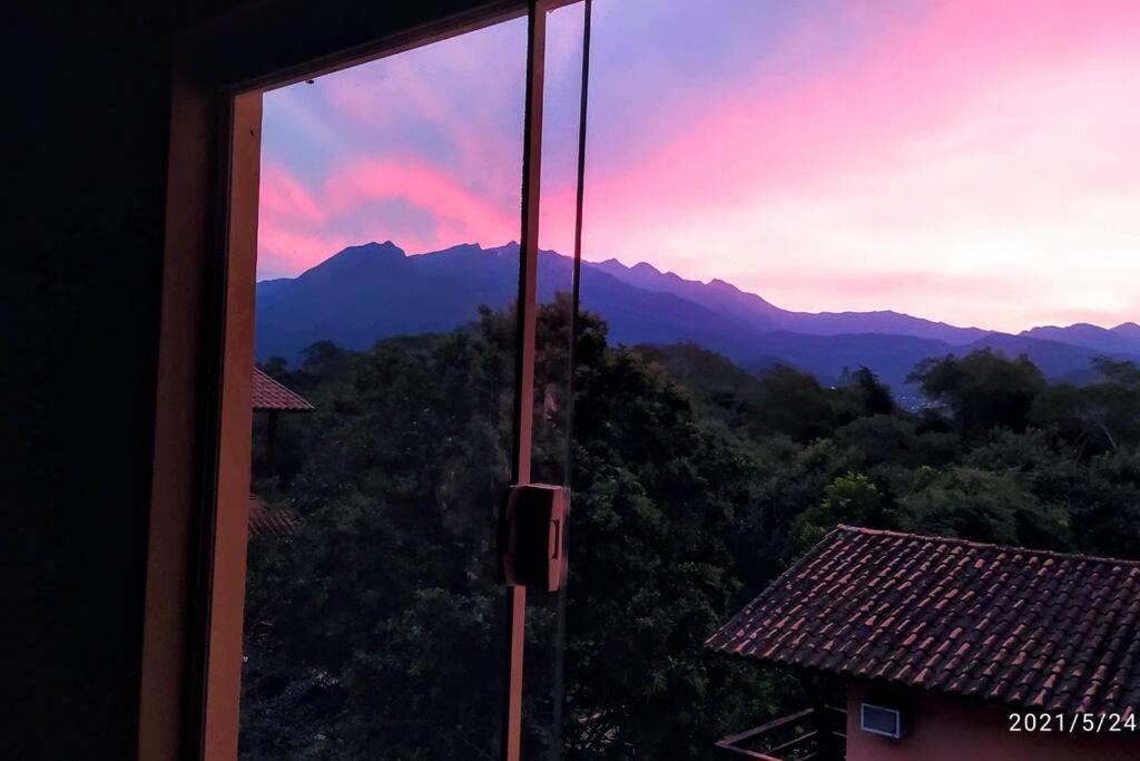 uma vista para as montanhas a partir da janela de uma casa em PENEDO ACONCHEGO LOFT: VISTA, CONFORTO E NATUREZA! em Penedo