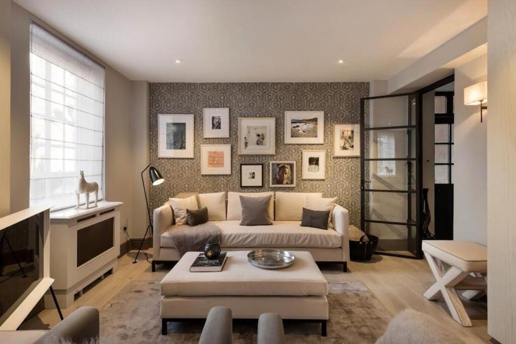 a living room with a couch and a tv at Knightsbridge & Chelsea Lux apartments in London