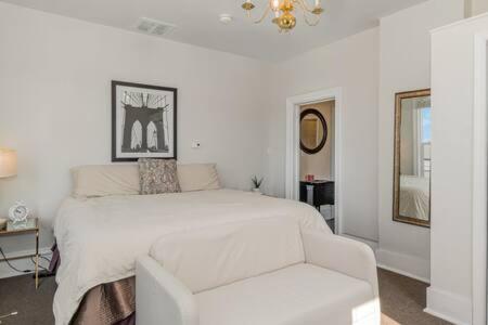 a white bedroom with a white bed and a chair at Studio w King Bed Walking distance to Beach & Shops in Michigan City