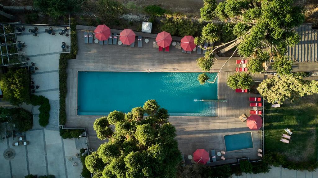 an overhead view of a swimming pool with red umbrellas at Leonera Hotel in La Leonera