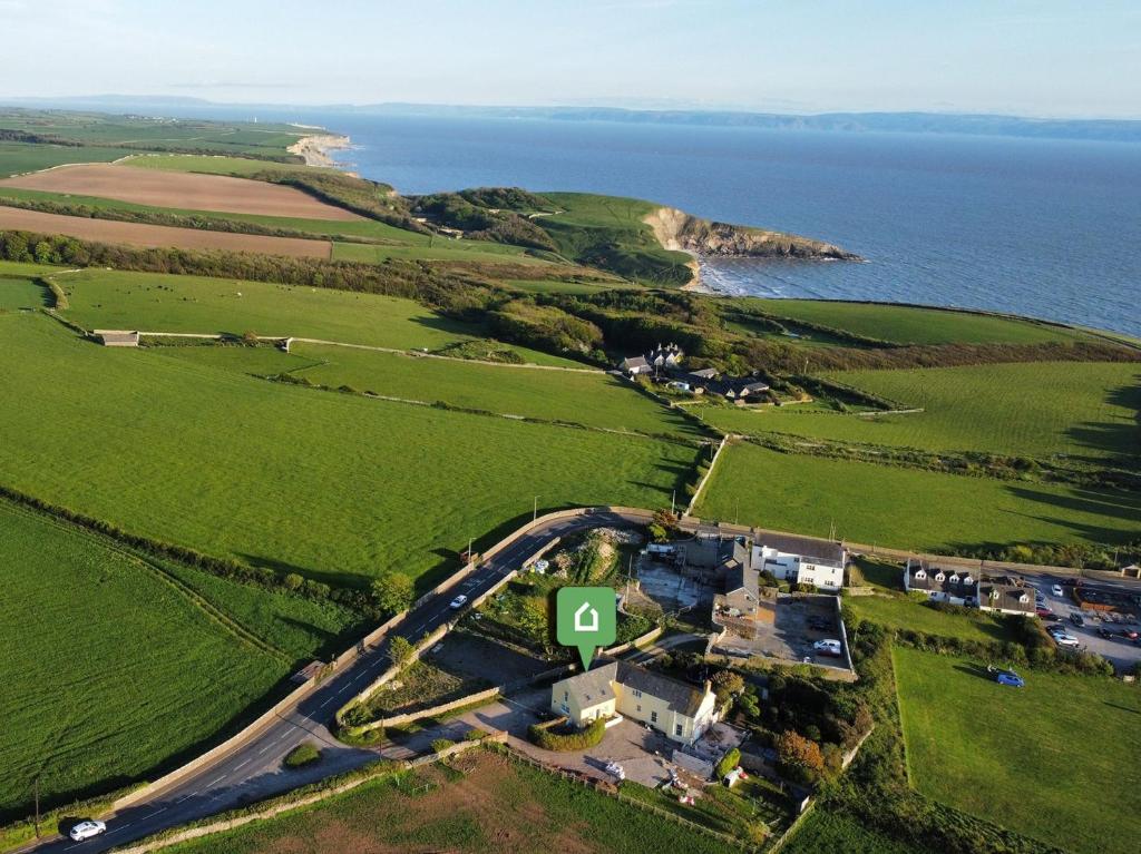 an aerial view of a house on a road next to the ocean at 3 Bed in Southerndown 57715 in Southerndown