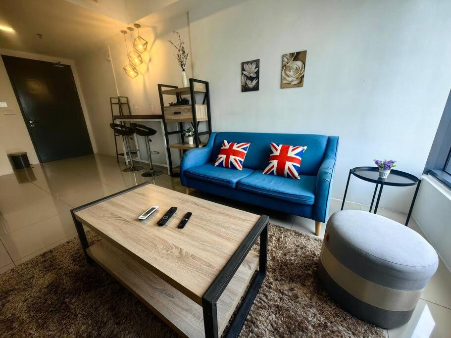 a living room with a blue couch and a coffee table at LS Tropicana 218*Sea View*1BR*Georgetown*King Bed in George Town
