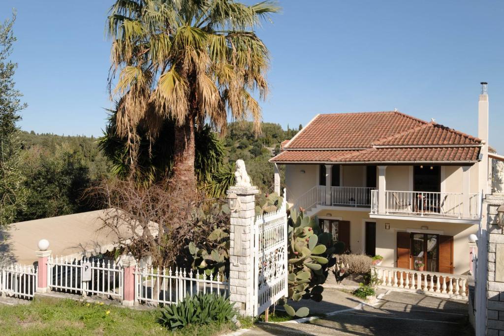 una casa con una valla blanca y una palmera en House Belelis, en Afionas