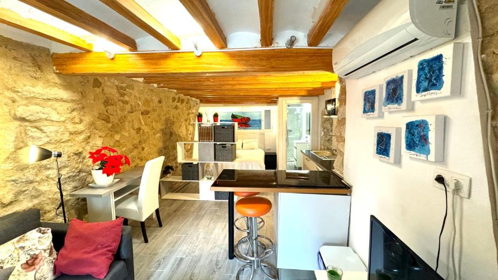 a small kitchen and living room in a tiny house at Loft de piedra en centro histórico - Casco Antiguo in Alicante