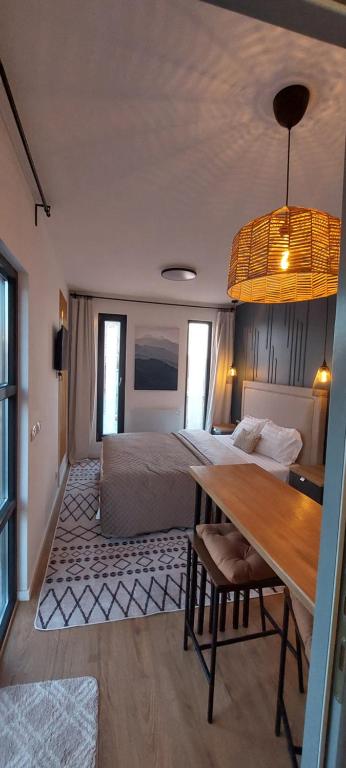 1 dormitorio con cama, mesa de madera y comedor en Casuta de Oaspeti en Ghermăneşti