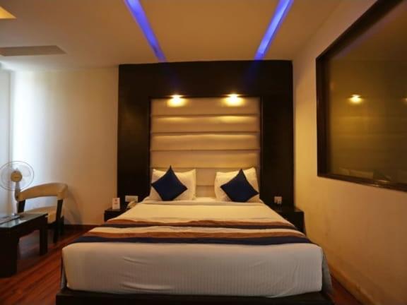 a bedroom with a large bed with blue lights on it at Hotel Luxury Stay Near Us embassy Delhi in New Delhi