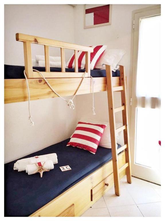 a bunk bed with two bunk beds and a ladder at Le case dei Venti in Tanaunella