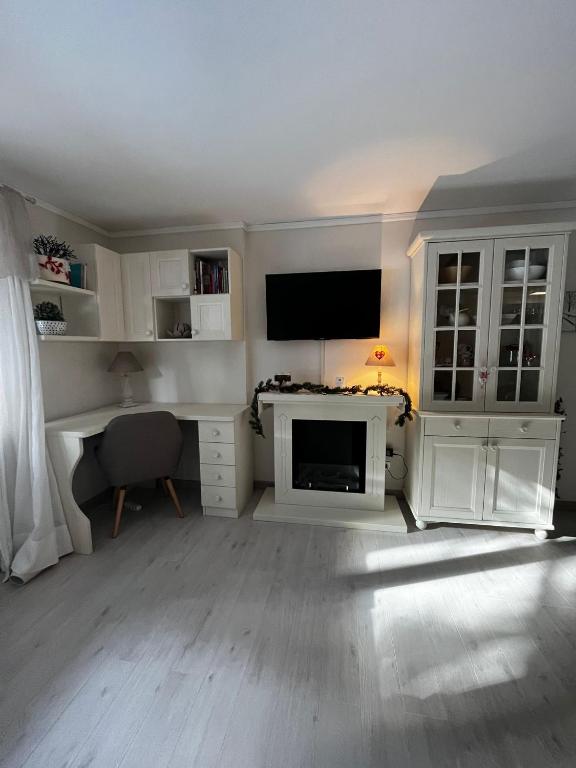 a living room with a tv and a desk with a computer at La casa di Ele in Morgex