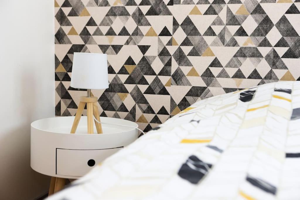 een slaapkamer met een bed en een tafel met een lamp bij Duplex hyper centre : Le Cosy in Niort